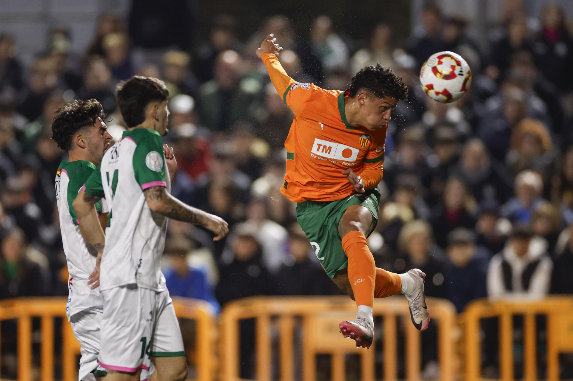 El extremo costarricense del Valencia Warren Madrigal (d) remata un balón durante el encuentro de la Copa del Rey disputado contra el el CP Parla Escuela, el 26 de noviembre de 2024, en el estadio Las Américas de Madrid. EFE/ Sergio Pérez