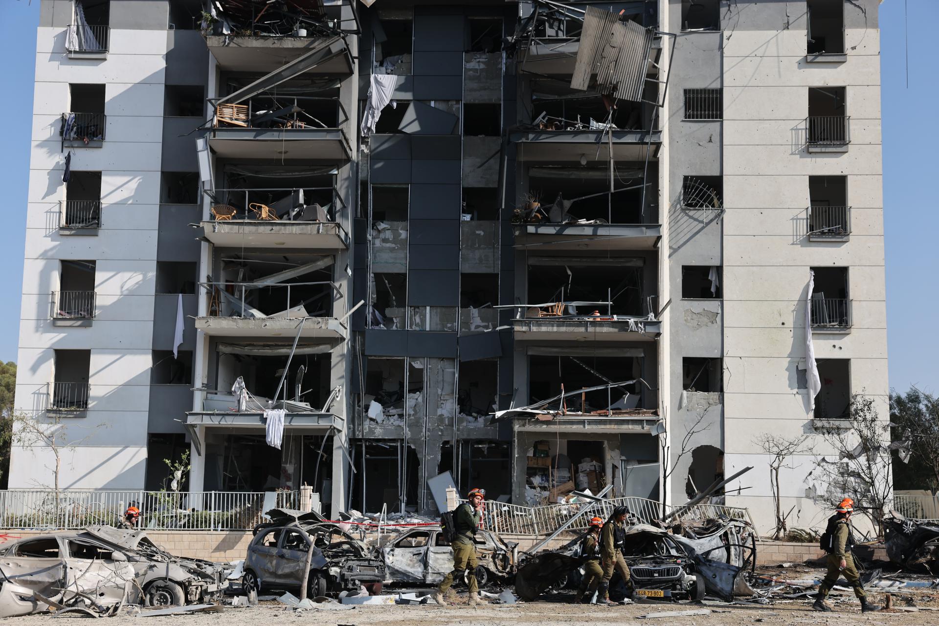 Miembros de un equipo de rescate israelí caminan junto a un edificio residencial en el que impactaron misiles balísticos iraníes en Beersheva, sur de Israel, el 20 de junio de 2025. EFE/EPA/ABIR SULTAN