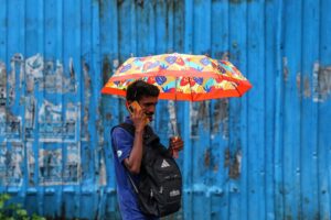 Un hombre se guarece de la lluvia en Bombay, la India. EFE/EPA/DIVYAKANT SOLANKI