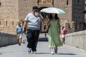 TOLEDO (ESPAÑA), 29/06/2025.- Los turistas se protegen del sol durante la ola de calor en Toledo este domingo. Ninguna comunidad de la geografía española se libra este domingo de los avisos por altas temperaturas, que son de nivel naranja en doce de ellas, con mayor incidencia en zonas del suroeste peninsular. EFE/Ángeles Visdómine