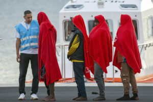 Imagen de archivo de un agente de la Agencia Europea de Fronteras y Costas (Frontex) junto a un grupo de inmigrantes rescatados por Salvamento Marítimo en aguas cercanas a Lanzarote. EFE/Adriel Perdomo