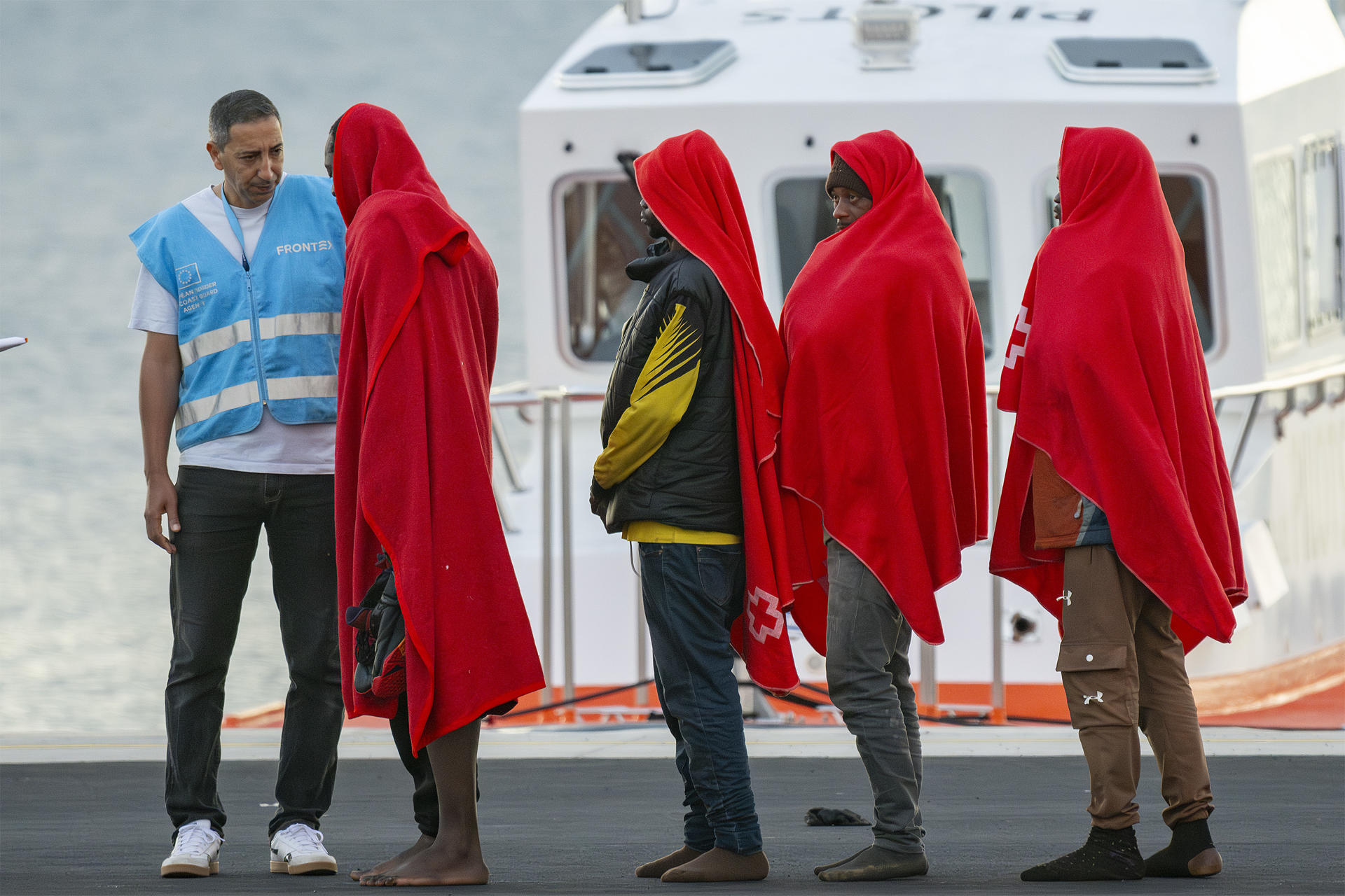 Imagen de archivo de un agente de la Agencia Europea de Fronteras y Costas (Frontex) junto a un grupo de inmigrantes rescatados por Salvamento Marítimo en aguas cercanas a Lanzarote. EFE/Adriel Perdomo