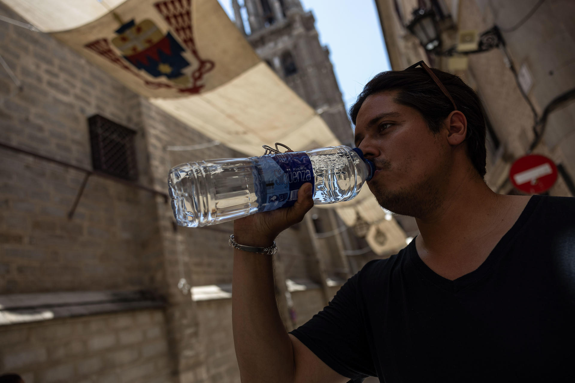 Toledanos y turistas se protegen del calor buscando sombras y bebiendo por las calles de Toledo. EFE/Ismael Herrero