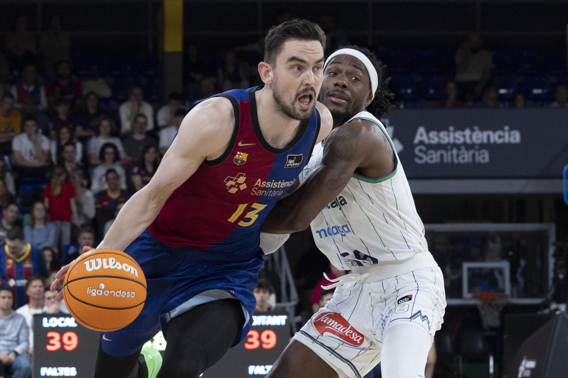 El jugador del FC Barcelona, Tomas Satoransky (i) con el balón ante el jugador del Unicaja Málaga Kendrick Perry durante el partido de la jornada 29 de la Liga Endesa que disputaron en el Palau Blaugrana de Barcelona. EFE/Marta Pérez