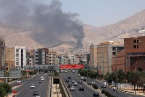 Vehículos circulan por una autopista mientras se eleva humo al fondo desde una refinería de petróleo, al noroeste de Teherán, Irán. EFE/ Abedin Taherkenareh