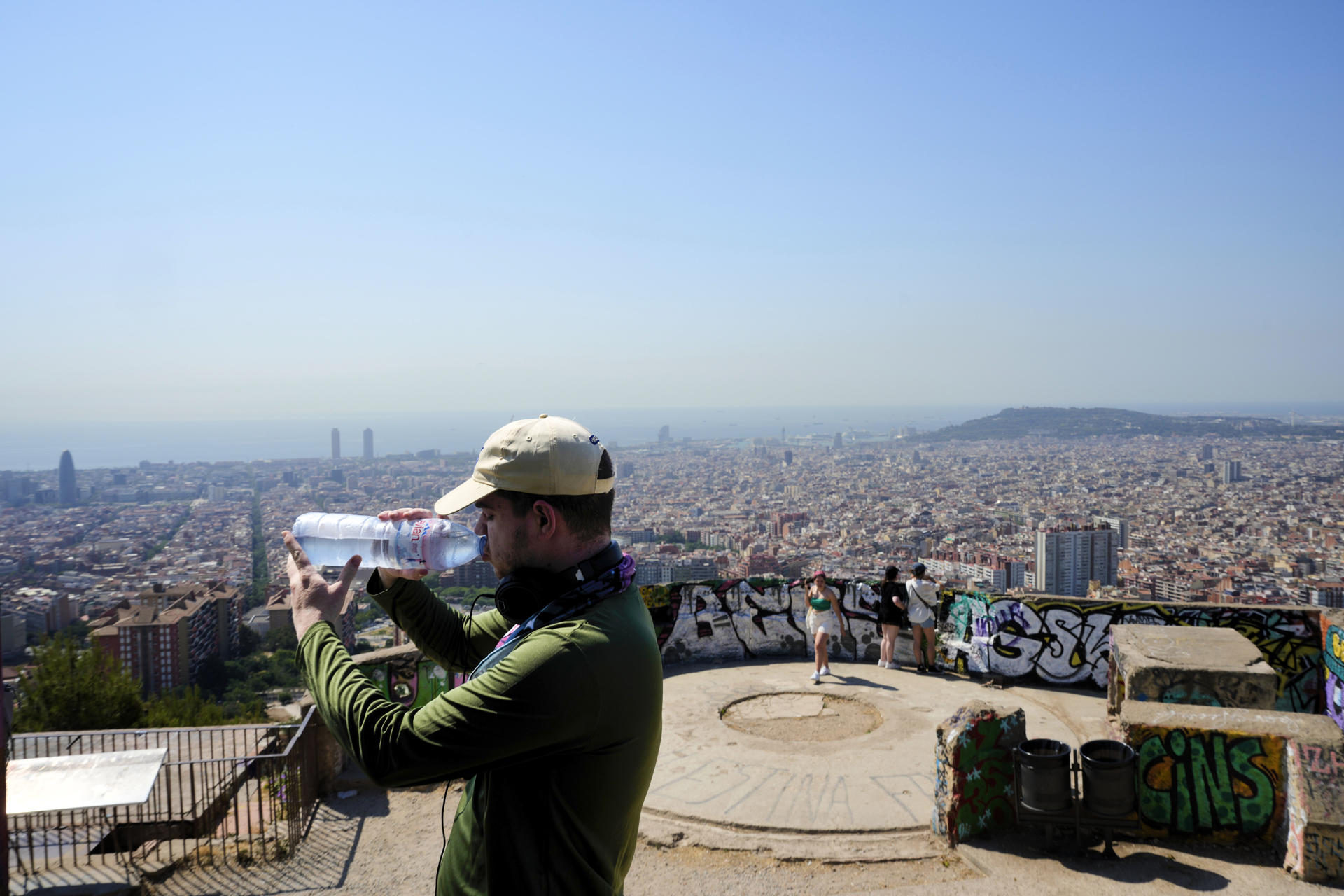 Turistas en el Turó de la Rovira de Barcelona este lunes cuando Cataluña vive el tercer día de la primera ola de calor de 2025. EFE/Alejandro García