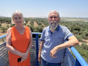 Nieves González y Carlos Ortega son una pareja que viven en una casa en el municipio de Gerena (Sevilla) y posan en un balcón con la imagen al fondo de los terrenos donde hay previsto el proyecto de un campo solar que rodeará su vivienda y les hará imposible vivir en ella, por lo que han comenzado un proceso para intentar paralizarlo. EFE/Fermín Cabanillas