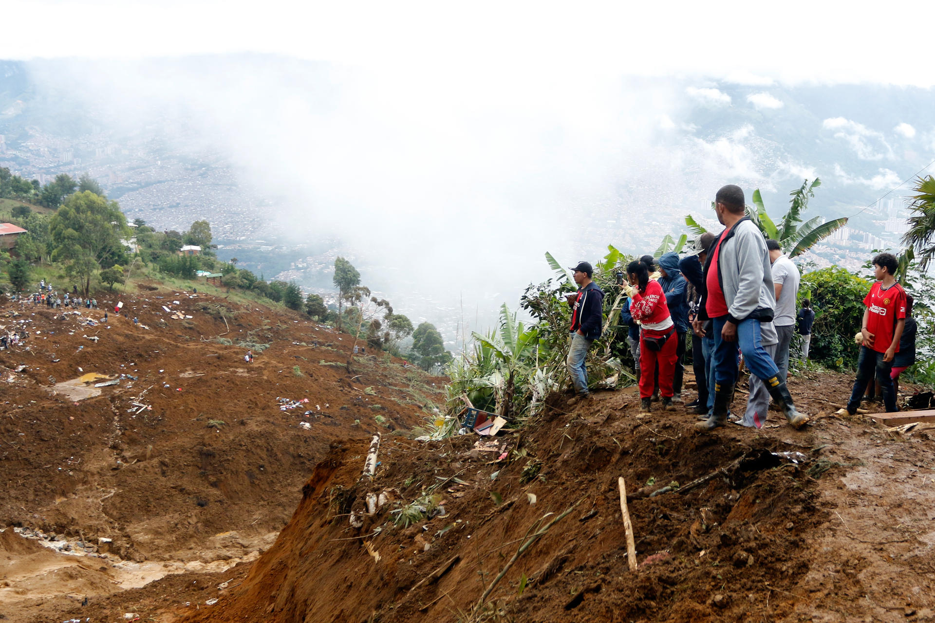 Personas observan la zona afectada por una riada este martes, en Bello (Colombia). Varios muertos y heridos dejó una riada provocada por un fuerte aguacero en la ciudad colombiana de Bello, que hace parte del área metropolitana de Medellín, en el departamento de Antioquia (noroeste). EFE/ STR