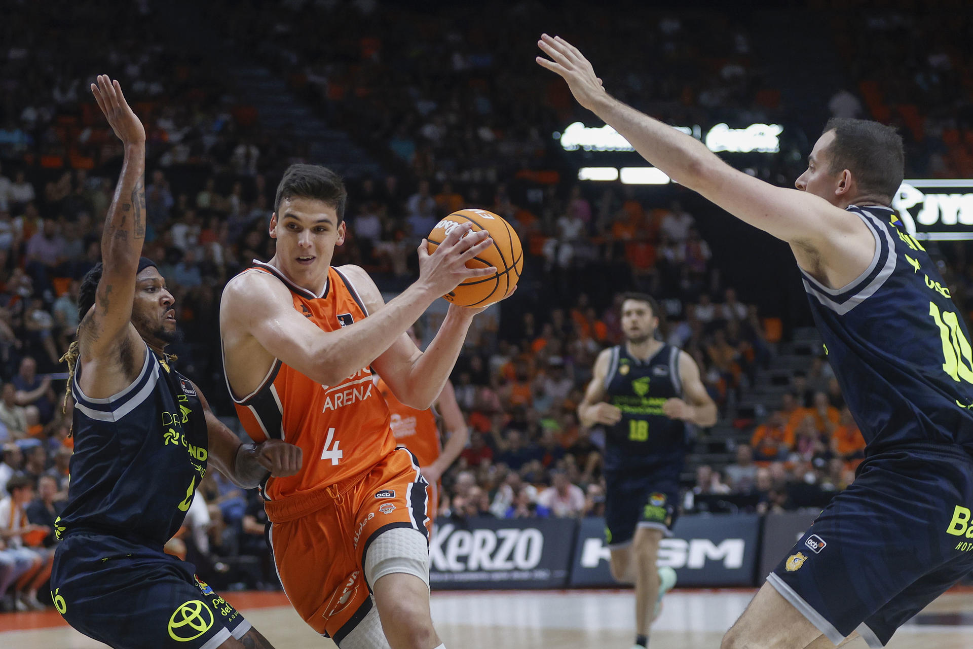 El alero del Valencia Jaime Pradilla (c) en acción ante Andrew Albicy del Gran Canaria este lunes, durante el partido de baloncesto correspondiente a los cuartos final de la Liga Endesa, disputado entre Valencia Basket y Dreamland Gran Canaria, en el pabellón de la Fuente San Luis de Valencia. EFE/ Miguel Ángel Polo