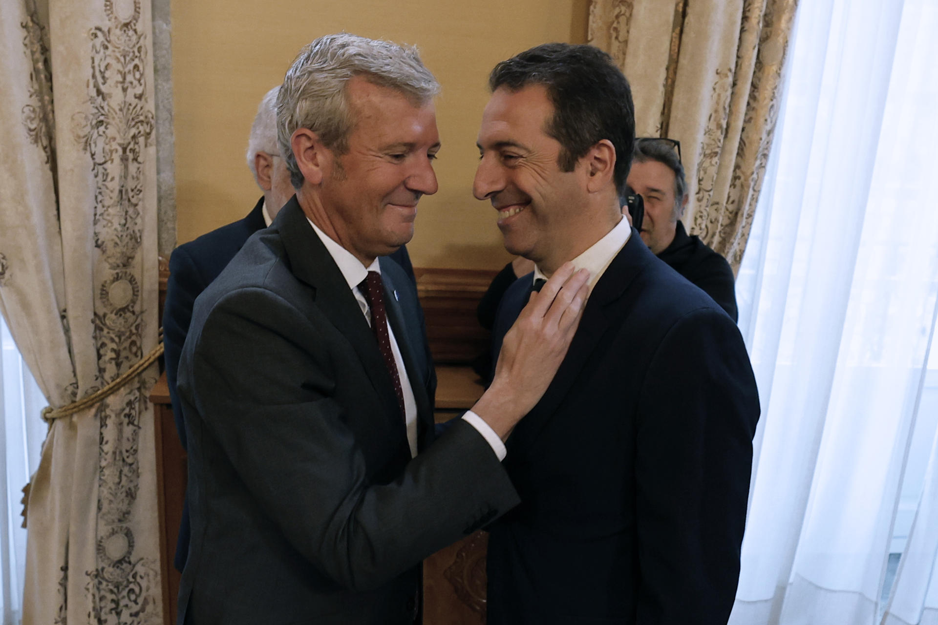 El presidente de la Xunta, Alfonso Rueda (i), saluda al exconselleiro de Mar, Alfonso Villares (d), durante el acto de toma de posesión de su sucesora en el cargo, Marta Villaverde, este jueves en Santiago de Compostela. Alfonso Villares dimitió ayer tras una denuncia de la presentadora Paloma Lago contra él por agresión sexual. EFE/Lavandeira jr.