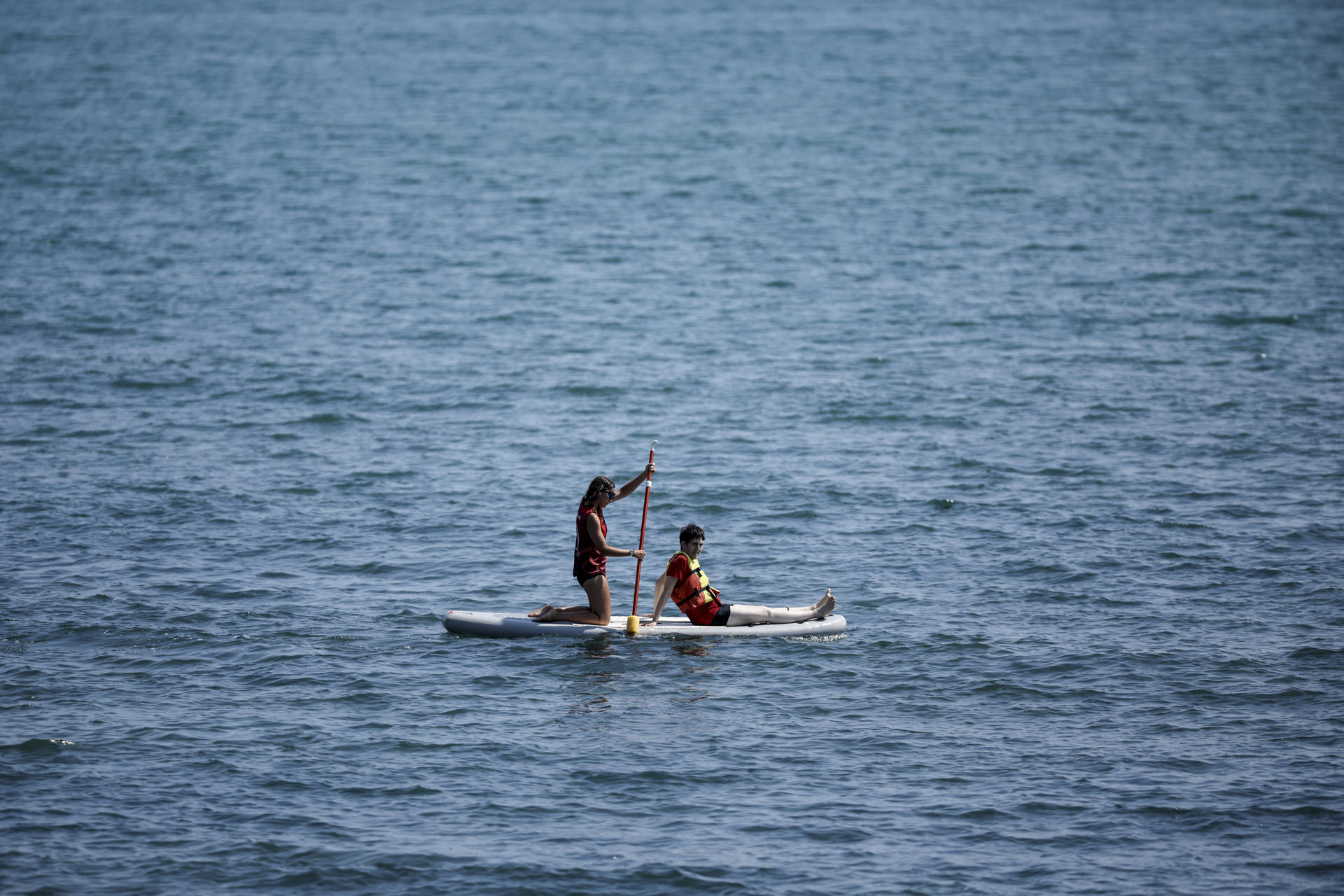 Una pareja realiza paddle-surf en aguas de la playa de la Malvarrosa durante el viernes. EFE/Biel Aliño