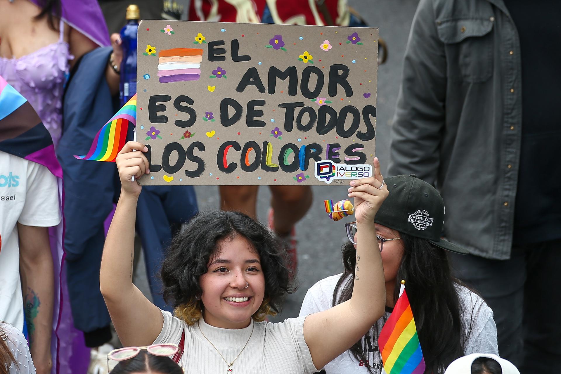 Una integrante de la comunidad LGBT+ sostiene un cartel en la Marcha del Orgullo este sábado, en Quito (Ecuador). EFE/ José Jácome
