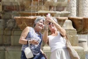 Turistas se fotografían junto a una fuente en el centro histórico de Sevilla, este martes en el que cinco comunidades de la península se encuentran en nivel de riesgo naranja (importante), con temperaturas de hasta 41 grados en Andalucía.EFE/José Manuel Vidal