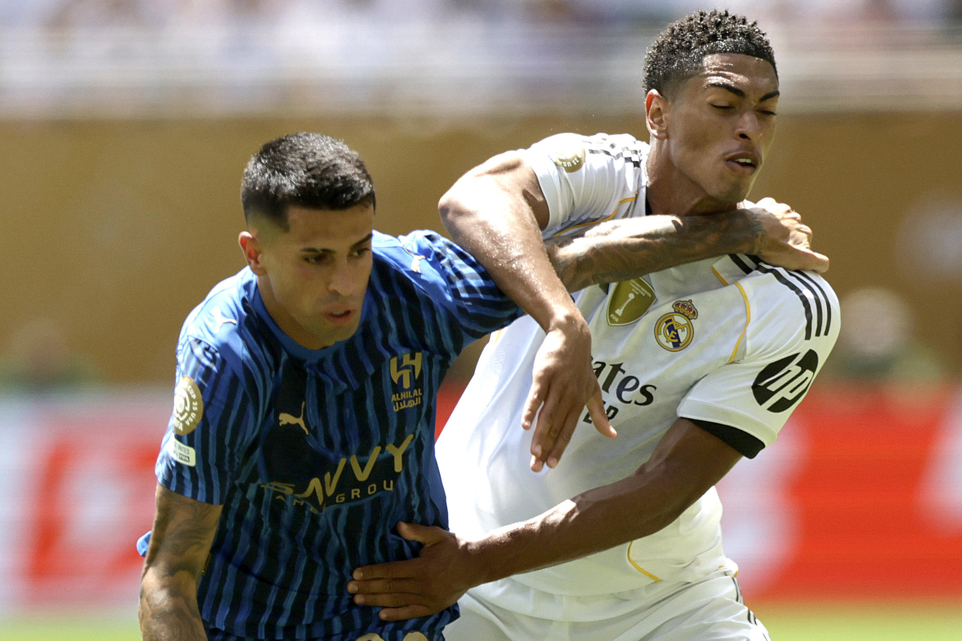 El club Al Hilal, dirigido por el italiano Simone Inzaghi, enredó este miércoles el debut del Real Madrid en el Mundial de Clubes, Figuras como Jude Bellingham (d) fueron marcados a presión, como muestra João Cancelo (i) durante el partido en el estadio Hard Rock de Miami que terminó 1-1. EFE/Andre Coelho