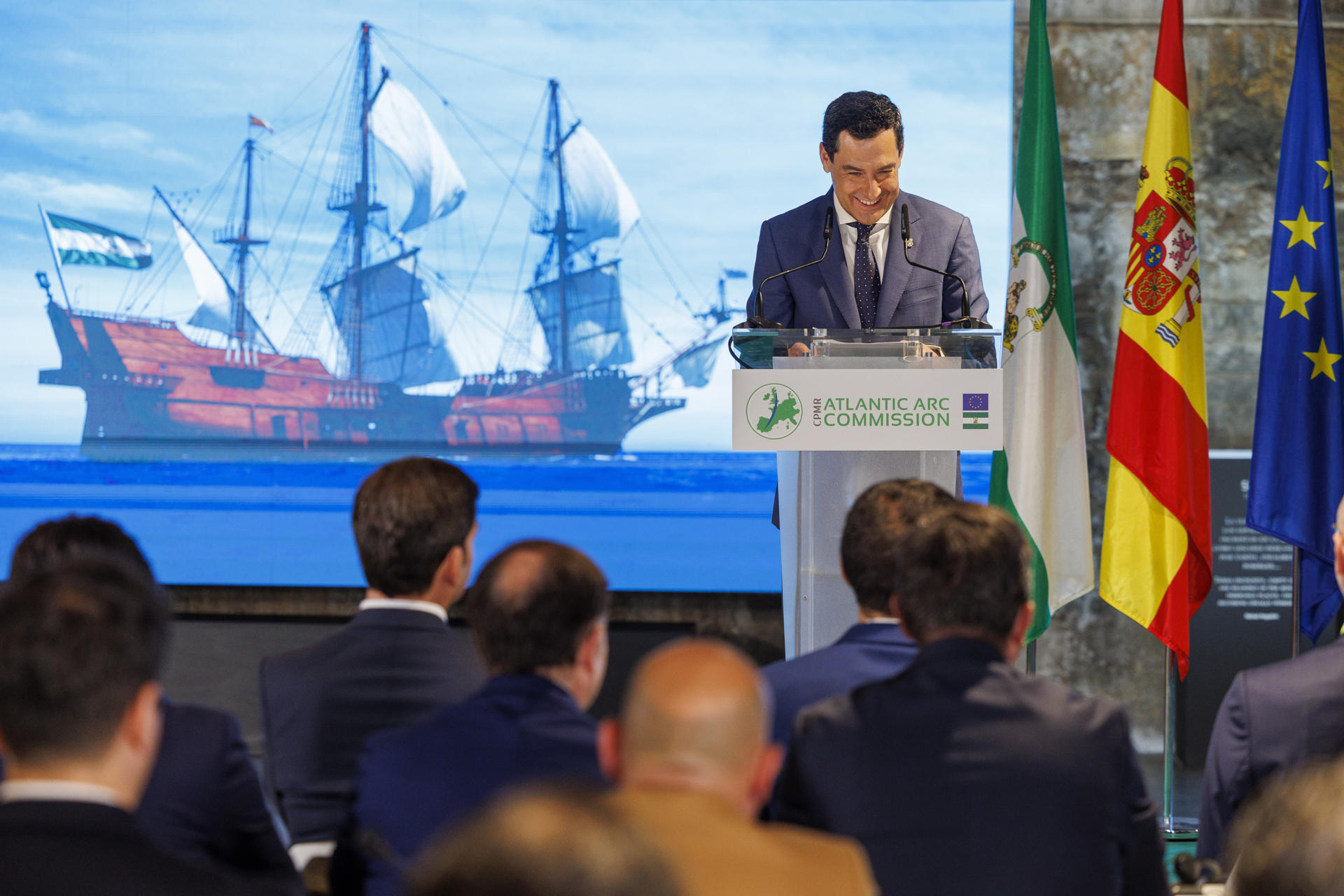 El presidente de la Junta de Andalucía, Juanma Moreno, durante su intervención en el acto de clausura de la I Jornada de la Asamblea General de la Comisión Arco Atlántico, que se desarrolla este jueves en el Centro Nao Victoria de Sevilla. EFE/ Julio Muñoz