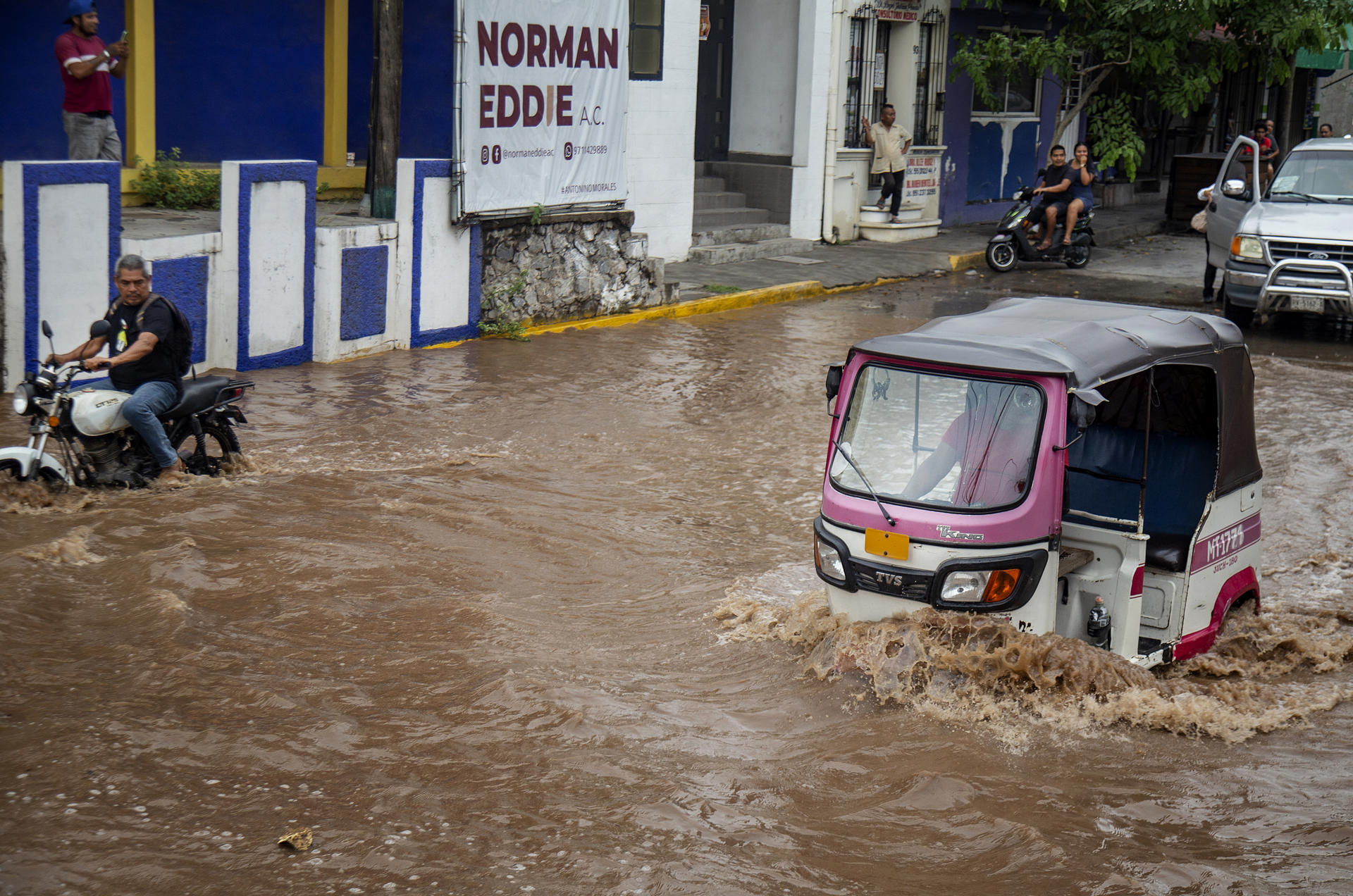 Vehículos transitan por una calle inundada tras el paso del huracán 'Erick' este jueves, en Juchitán (México). EFE/ Luis Villaobos