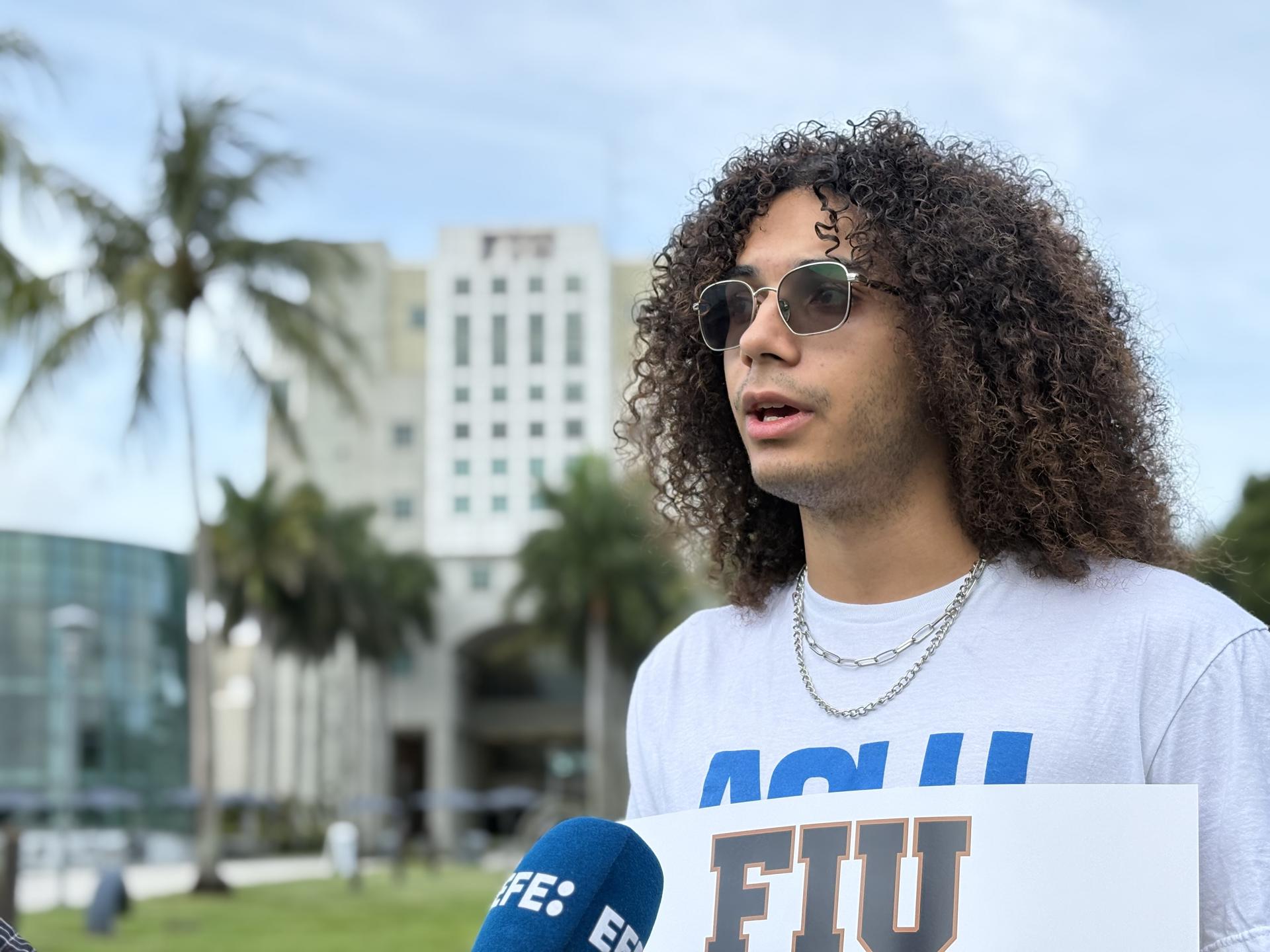 Dariel Gómez, estudiante de sociología de la Universidad Internacional de Florida (FIU), habla con la prensa durante una protesta este jueves, en Miami (Estados Unidos). EFE/Alberto Boal