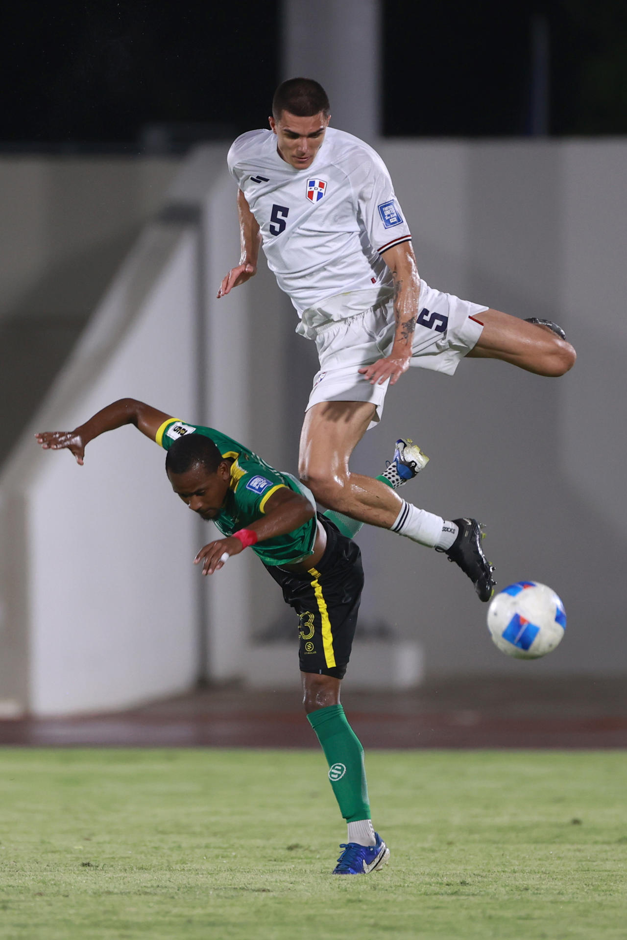 Noah Dollenmayer (arriba) de República Dominicana disputa el balón con Marcus Bredas de Dominica. EFE/Orlando Barria