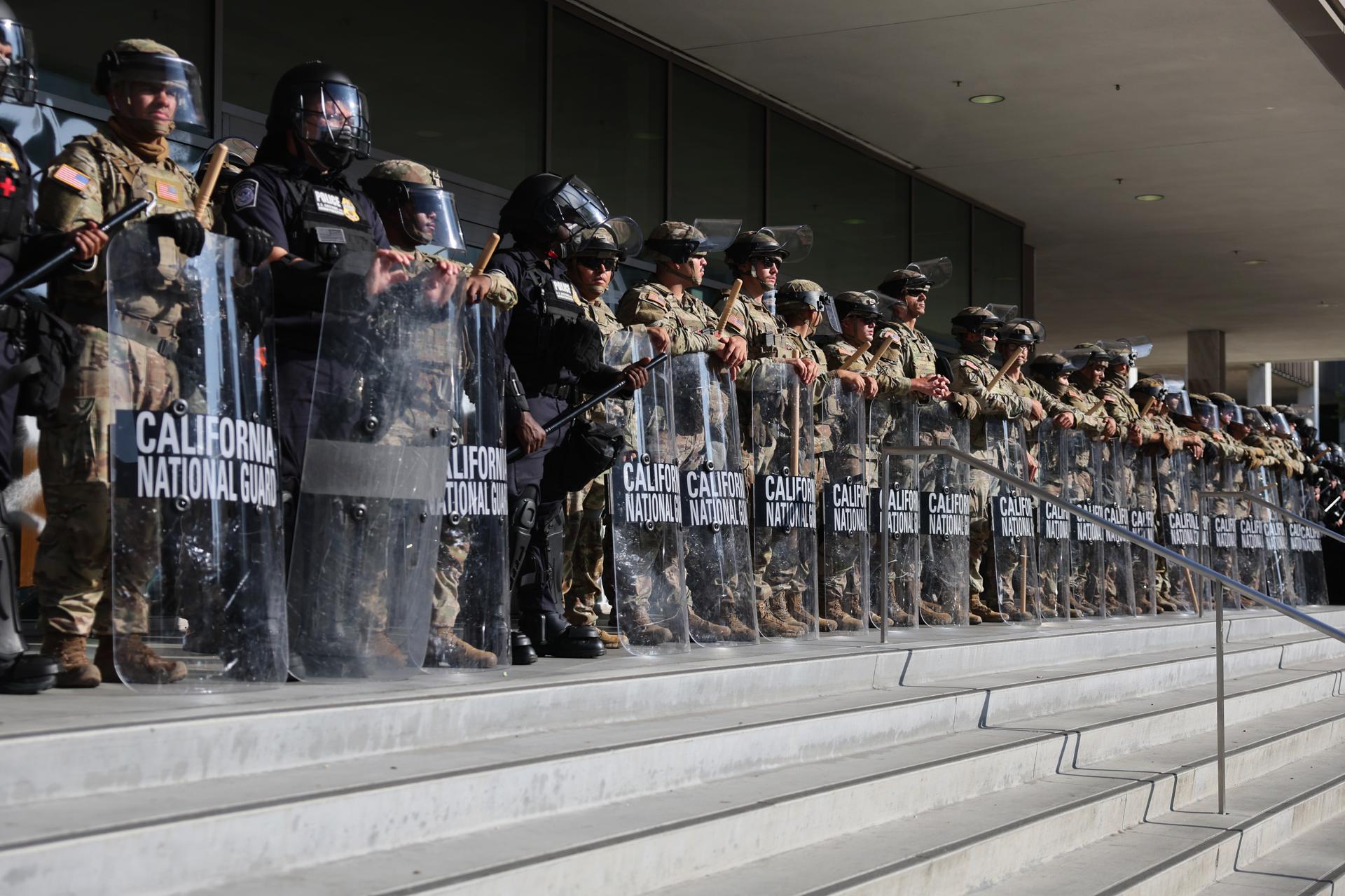 Miembros de la Guardia Nacional de California se encuentran frente al Edificio Federal durante las protestas provocadas por redadas migratorias en Los Ángeles, California, EE.UU. EFE/EPA/ALLISON DINNER