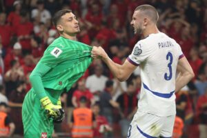 El jugador de Serbia Strahinja Pavlovic (d)agarra al portero Djordje Petrovic durante el partido de clasificación jugado en Tirana, Albania. EFE/EPA/MALTON DIBRA