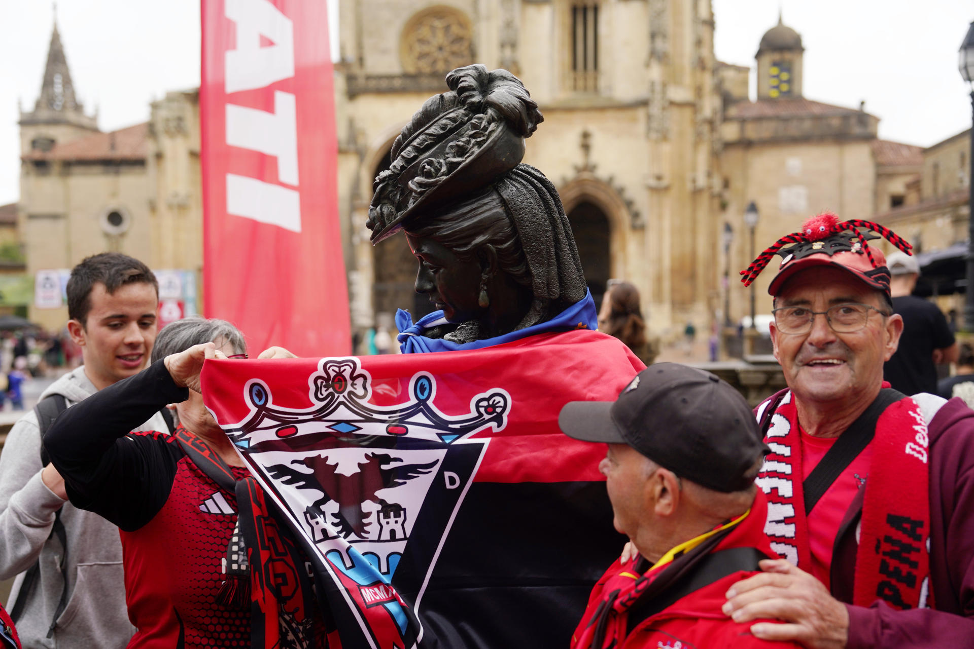 Aficionados del Mirandés colocan una bandera de su equipo a la estatua de la Regenta, antes del partido de la fase de ascenso a Primera División disputado entre el Oviedo y el Mirandés en el Carlos Tartiére de la capital del Principado. EFE/Paco Paredes