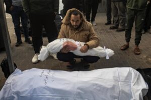 Un hombre sostiene el cuerpo envuelto de una niña mientras los palestinos lloran a sus muertos en el Hospital Al-Najjar tras un ataque aéreo israelí contra el campo de refugiados de Rafah, en el sur de la Franja de Gaza, el 21 de febrero de 2024. EFE/EPA/HAITHAM IMAD