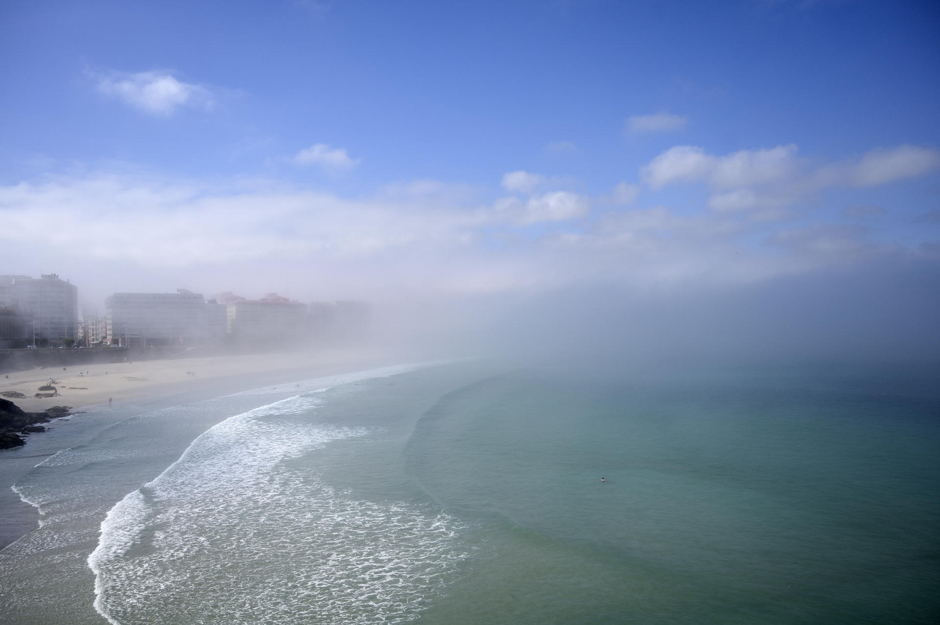 Vista de la niebla en los arenales de A Coruña este viernes cuando Galicia vivirá un episodio extremo de altas temperaturas en las que superarán los 40 grados en Ourense y la capital lucense subirá de 34°. EFE/Moncho Fuentes