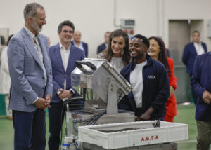 La reina Letizia (c) y el rey Felipe VI (i) escuchan las explicaciones de Carlos (d), uno de los profesionales que trabajan en la lonja de Burela (Lugo), durante su participación en la subasta de mercancía recién pescada en el marco de su visita a la localidad para interesarse de primera mano por la realidad del sector pesquero de A Mariña lucense. EFE/ Lavandeira Jr.