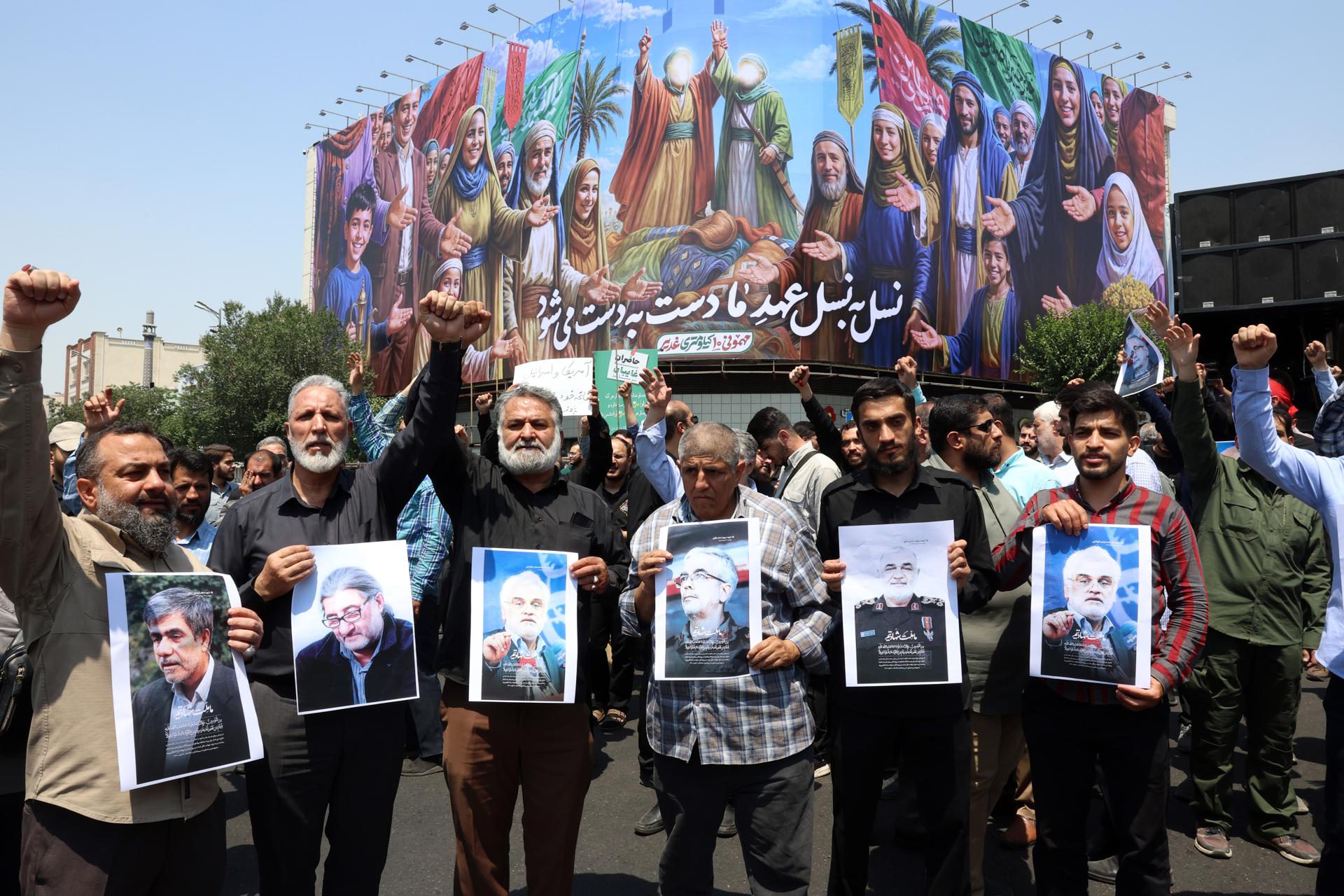 Iraníes sostienen retratos de los científicos y jefes de las Fuerzas Armadas y la Guardia Revolucionaria que murieron en los ataques aéreos israelíes, durante una protesta en Teherán, Irán, el 13 de junio de 2025. EFE/EPA/ABEDIN TAHERKENAREH