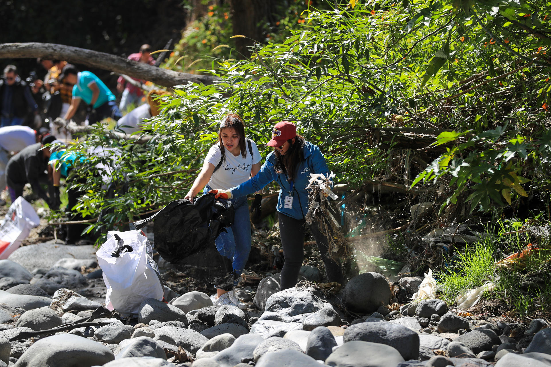 Decenas de personas fueron captadas este viernes, 20 de junio, durante una brigada de limpieza de materiales plásticos en el río San Pedro, liderara por el programa 'Galápagos Guardians', en Quito (Ecuador). EFE/José Jácome