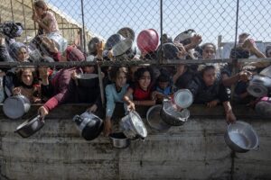Palestinos desplazados se agolpan frente a un comedor social para recibir raciones de alimentos al sur de la Franja de Gaza. EFE/ Haitham Imad