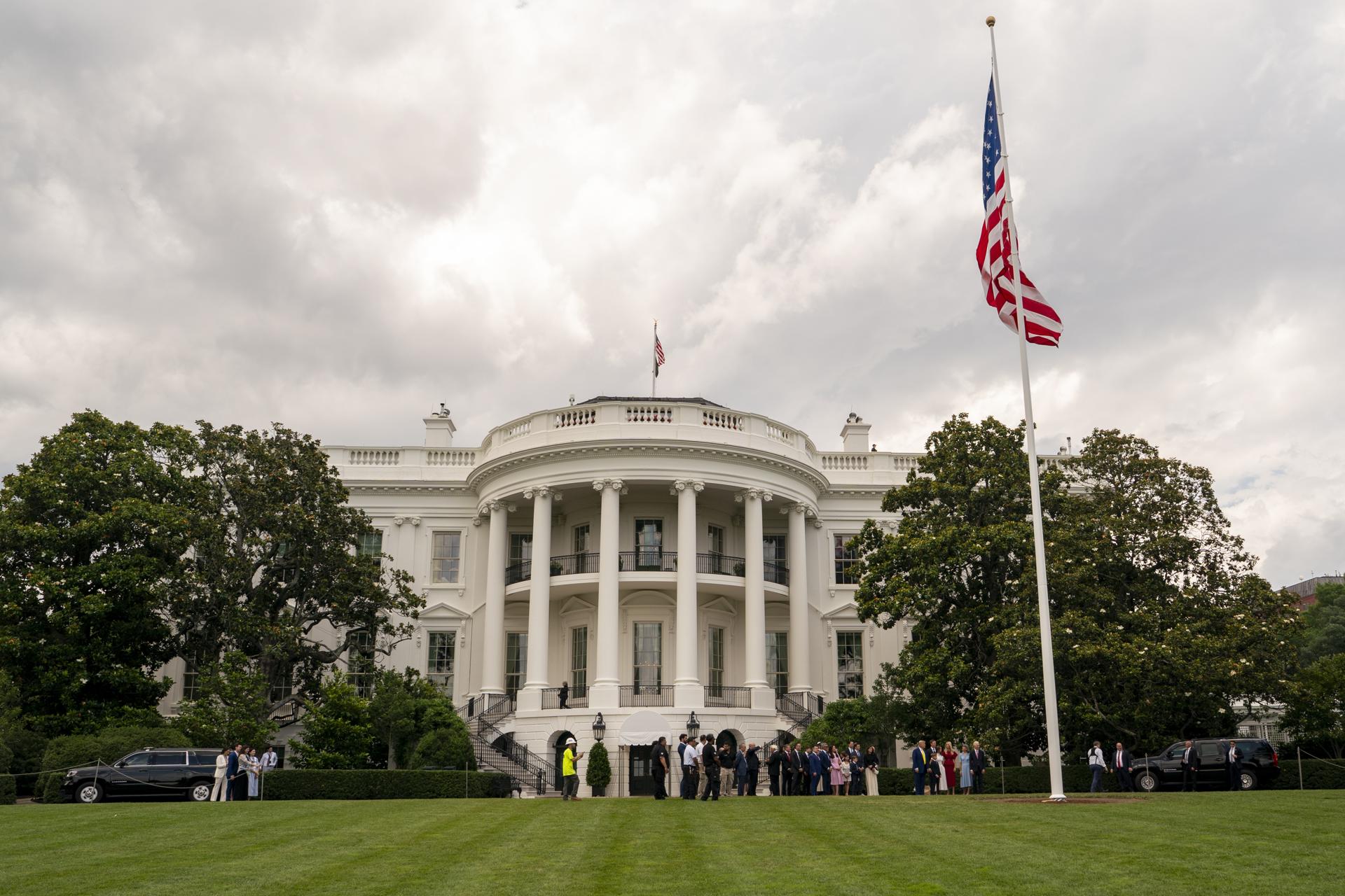 El presidente estadounidense, Donald Trump, y sus invitados observan cómo se iza la bandera estadounidense por primera vez en el nuevo mástil en el jardín sur de la Casa Blanca, en Washington, DC, EE. UU. EFE/EPA/KEN CEDENO / POOL
