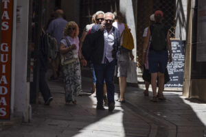 Un viandante camina entre las sombras protegiéndose del sol. EFE/Ismael Herrero