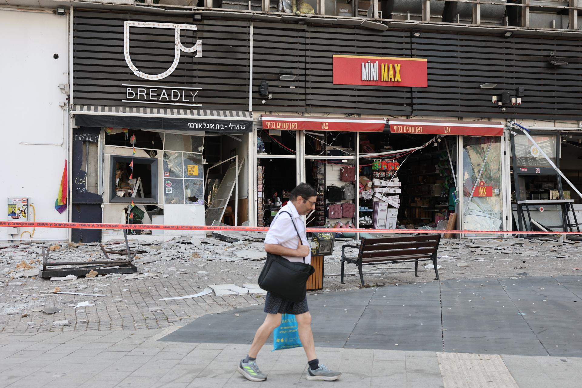 Una persona pasa junto a un centro comercial dañado tras un ataque con misiles balísticos en Tel Aviv, el 14 de junio de 2025. EFE/EPA/ABIR SULTAN