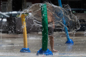 Un niño se refresca este viernes, en una plaza de la ciudad cántabra de Torrelavega. EFE/Pedro Puente Hoyos