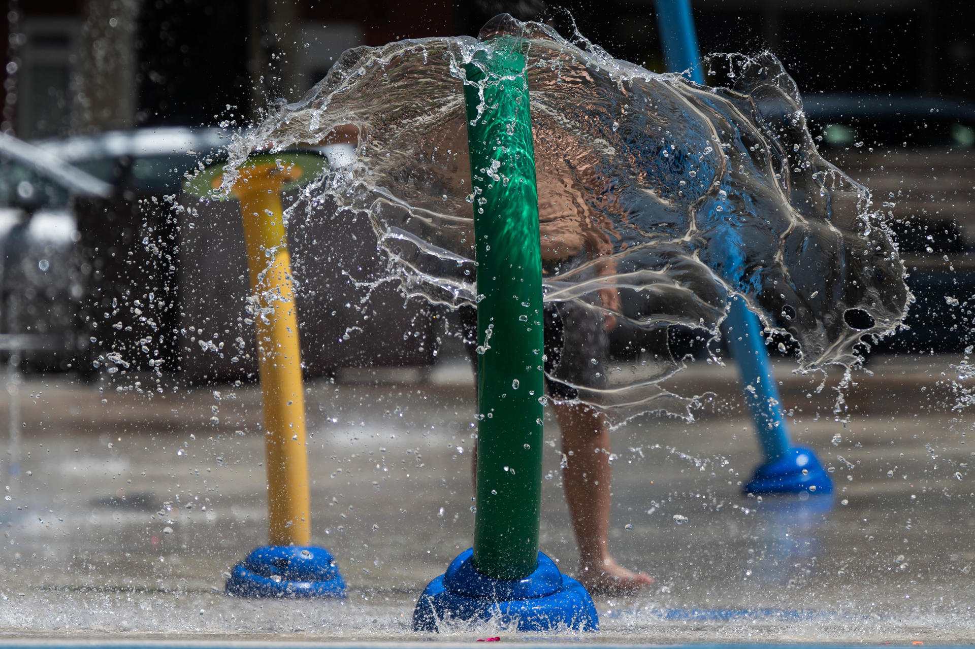 Un niño se refresca este viernes, en una plaza de la ciudad cántabra de Torrelavega. EFE/Pedro Puente Hoyos
