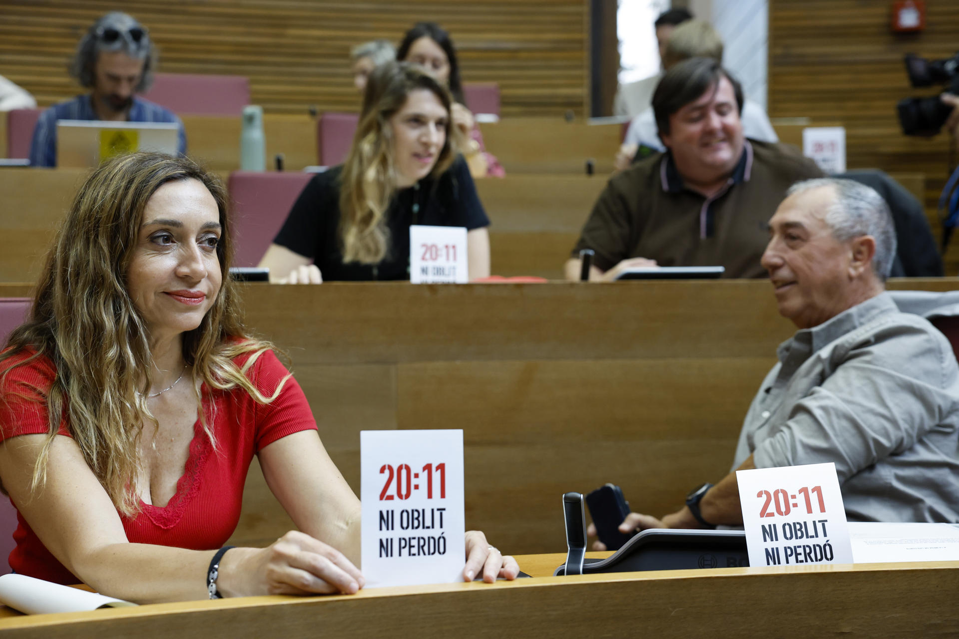La diputada de Compromís Isaura Navarro muestra un cartel con el lema "20:11 Ni olvido, ni perdón" durante el Pleno de Les Corts Valencianes en el que el president de la Generalitat, Carlos Mazón, responde a preguntas de los grupos parlamentarios sobre su gestión de la dana del 29 de octubre de 2024 y sobre la Conferencia de Presidentes celebrada el pasado viernes en Barcelona. EFE/Ana Escobar