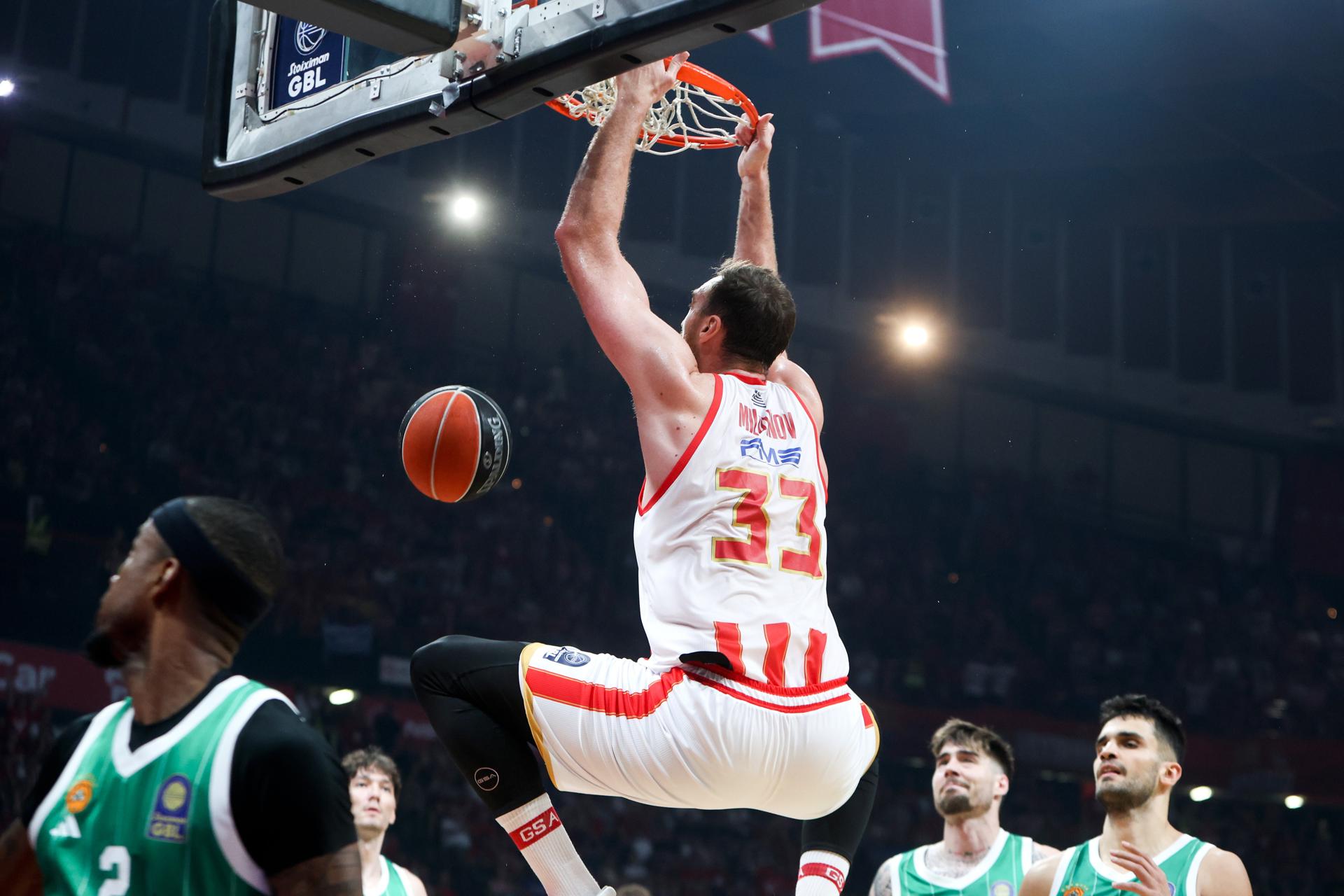 El jugado de Olympiacos Nikola Milutinov machaca el aro durante la final de la Liga griega. EFE/EPA/GEORGIA PANAGOPOULOU
