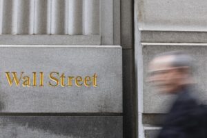 Fotografía de archivo de un transeúnte al pasar junto a un letrero de Wall Street, cerca a la sede de la Bolsa de Valores de Nueva York, en Manhattan (NY, EE.UU.). EFE/Justin Lane
