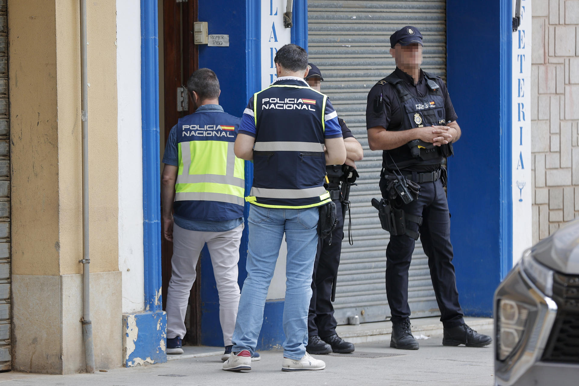 Efectivos de la Policía Nacional a las puertas del inmueble donde este miércoles un hombre de 34 años ha matado presuntamente a su mujer y a su hijo de 3 años en Algemesí (Valencia) y ha sido detenido. Los hechos han ocurrido sobre las seis de la mañana de este miércoles, tras una discusión familiar en un domicilio, según la llamada recibida por el 112, que avisó a la Policía. Los agentes de la Policía Nacional y Local desplazados al lugar encontraron los cuerpos de la mujer y su hijo y practicaron maniobras de reanimación al menor junto a los servicios sanitarios, pero no pudieron salvarle la vida. EFE/Manuel Bruque