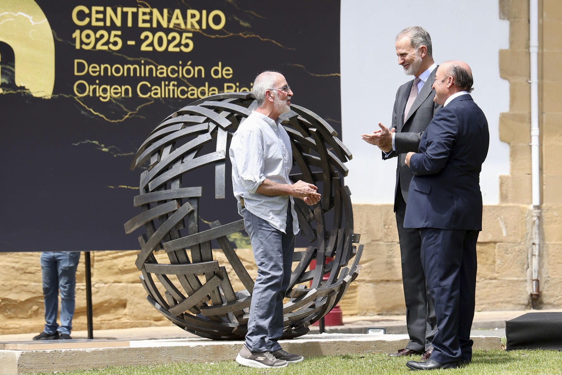 El rey Felipe VI ha inaugurado este jueves, en la ciudad riojana de Haro, el nuevo ‘Espacio Centenario de Rioja’ y la escultura ‘Somos tiempo’, obra del artista José A. Olarte (i), que conmemora los cien años de la Denominación de Origen Calificada (DOCa) Rioja y que refleja una esfera inacabada. A su lado, el presidente del Consejo Regulador, Fernando Ezquerro (d) EFE/Raquel Manzanares
