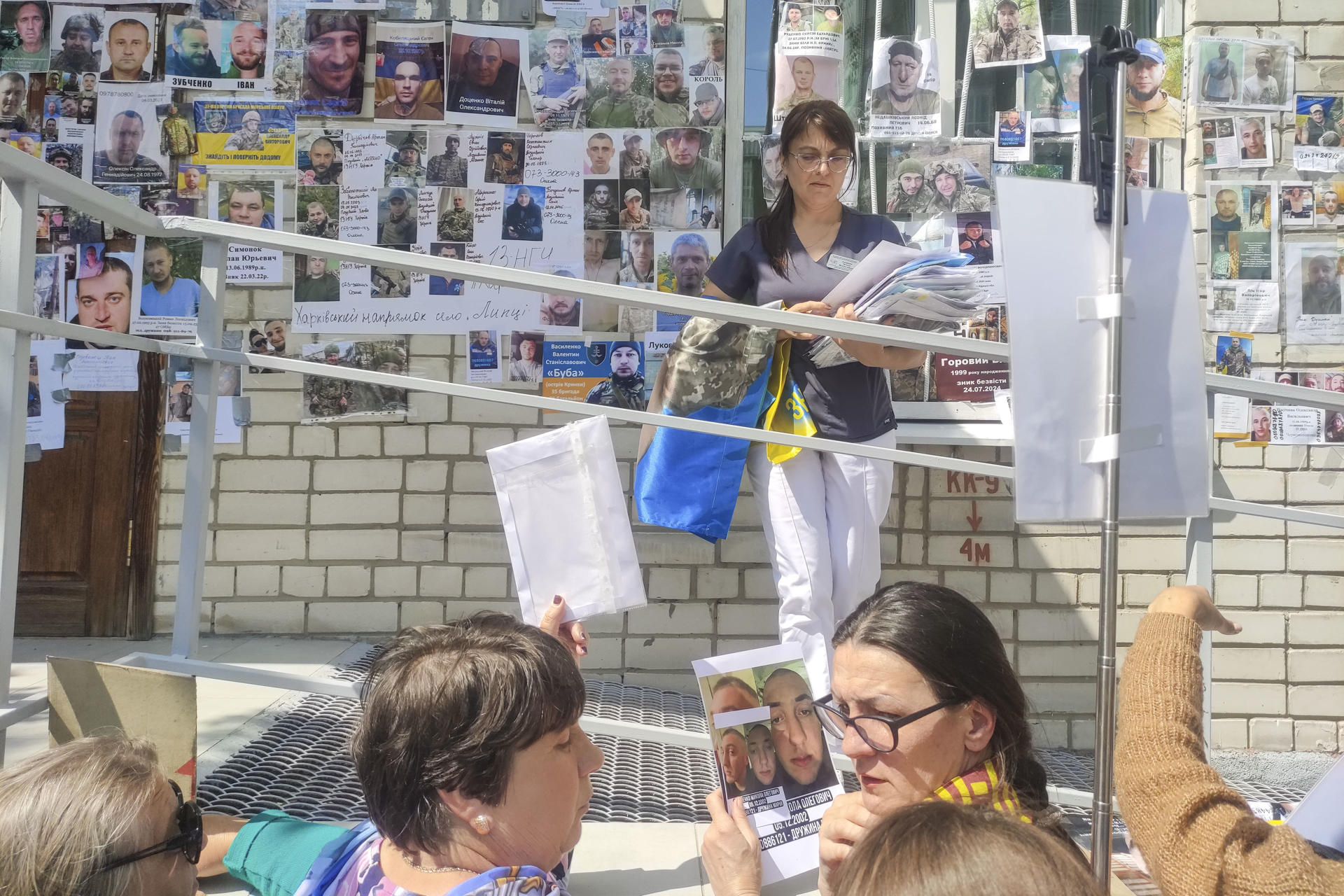 CHERNÍGUIV (UCRANIA), 12/06/2025.- Personal sanitario del centro que tratará a los prisioneros de guerra ucranianos liberados recibe fotografías de familiares de soldados desaparecidos que buscan de los cautivos retornados una prueba de vida de sus seres queridos. Las autoridades ucranianas y rusas anunciaron este jueves el intercambio del tercer grupo de prisioneros de guerra con Rusia en lo que va de semana, en base a lo acordado en la última ronda de contactos en Estambul. EFE/ Marcel Gascón
