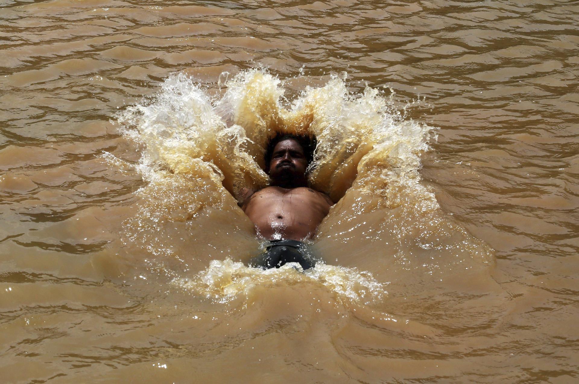 En la imagen de archivo, un hombre se da un baño para combatir una ola de calor en la localidad de Gauribidanur, en el distrito de Doddaballapur, India. EFE/Jagadeesh Nv