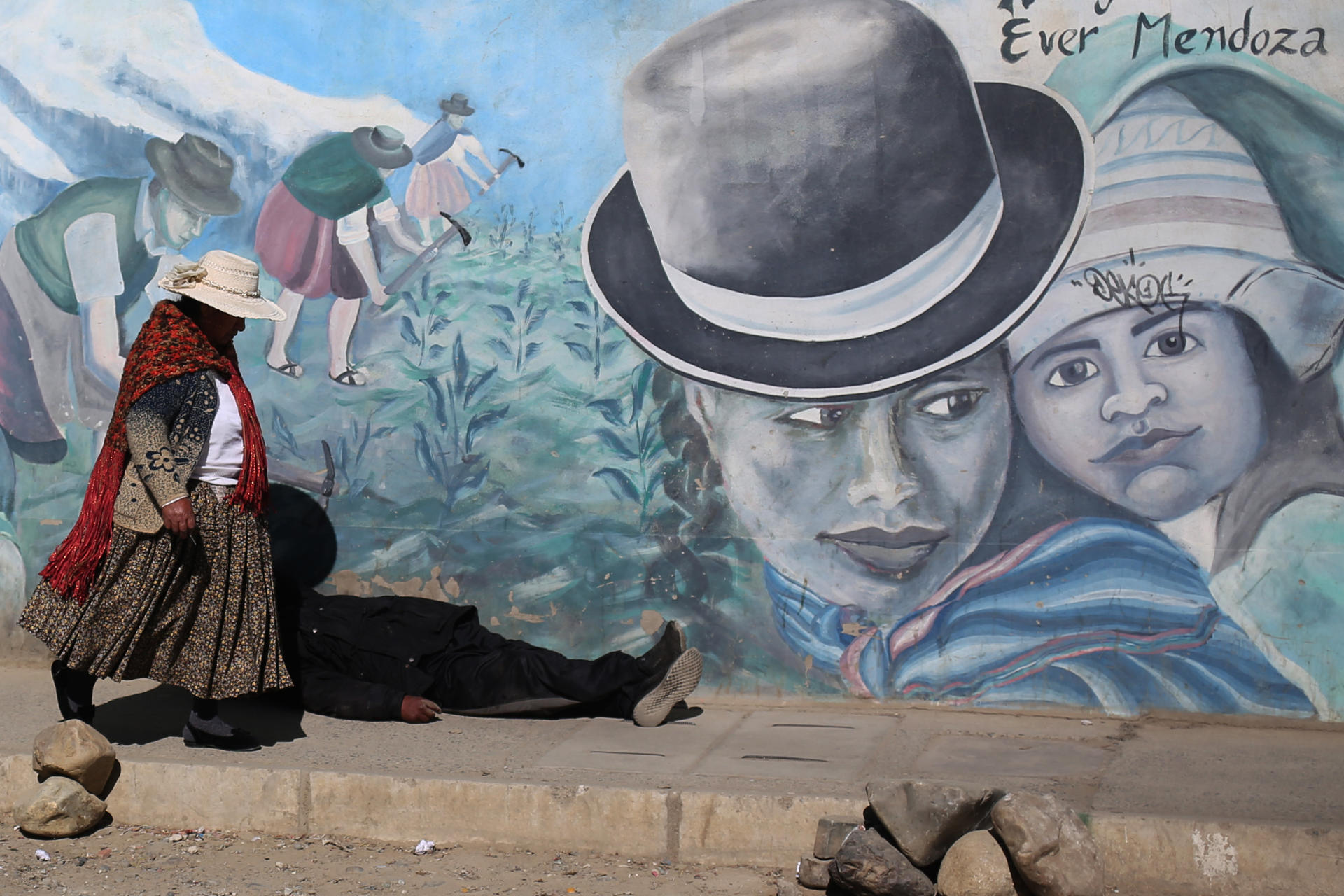 Una mujer aimara camina frente a un mural este martes, en El Alto (Bolivia). EFE/ Luis Gandarillas