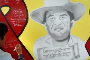 Fotografía de archivo de una mujer que escribe un mensaje sobre un mural con el rostro de Enrique "Kiki" Camarena. EFE/David Maung