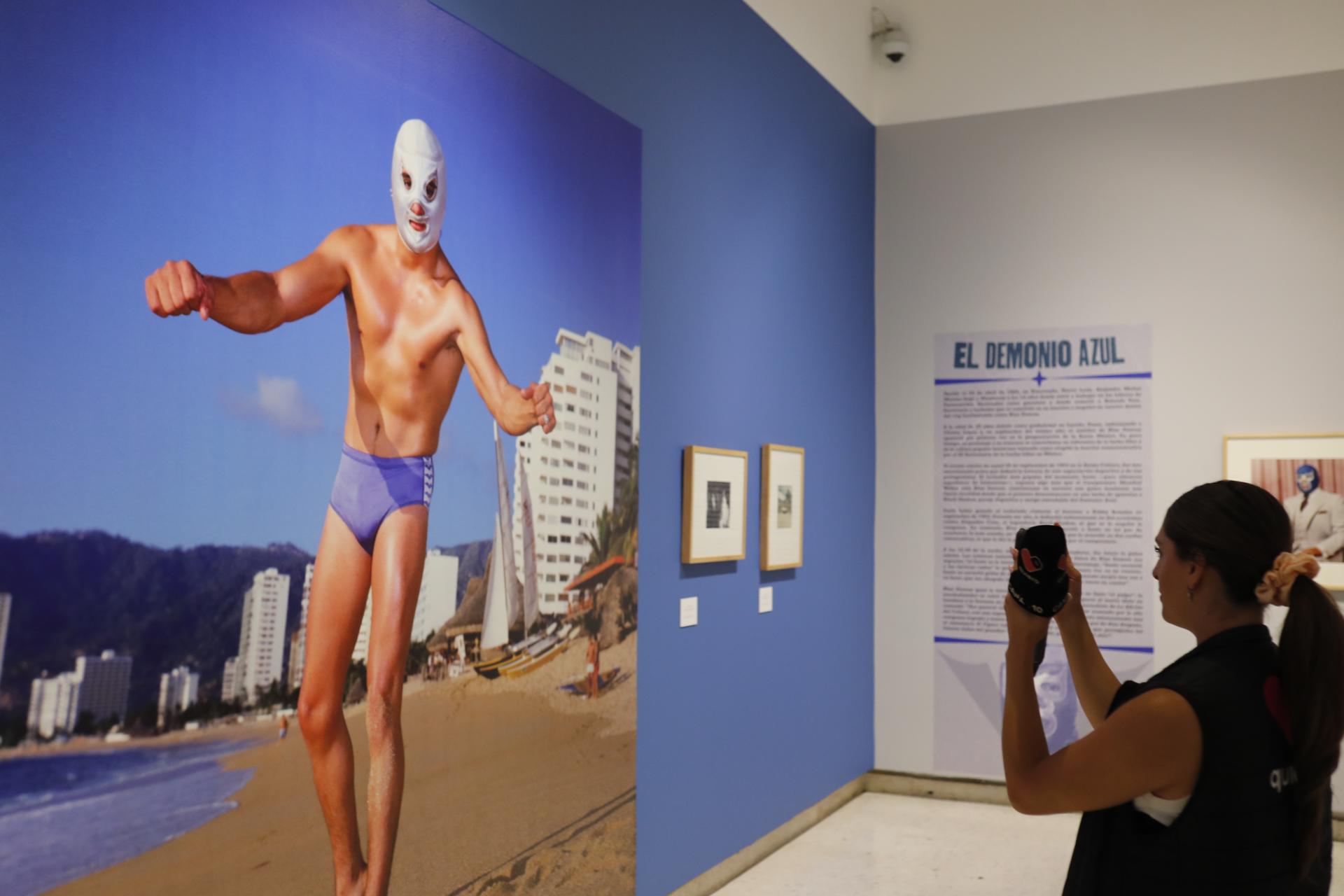 Una mujer toma una fotografía de la exhibición de lucha libre mexicana 'Kartharsis' este jueves, en el Museo de las Artes (MUSA) en Guadalajara (México). EFE/ Francisco Guasco