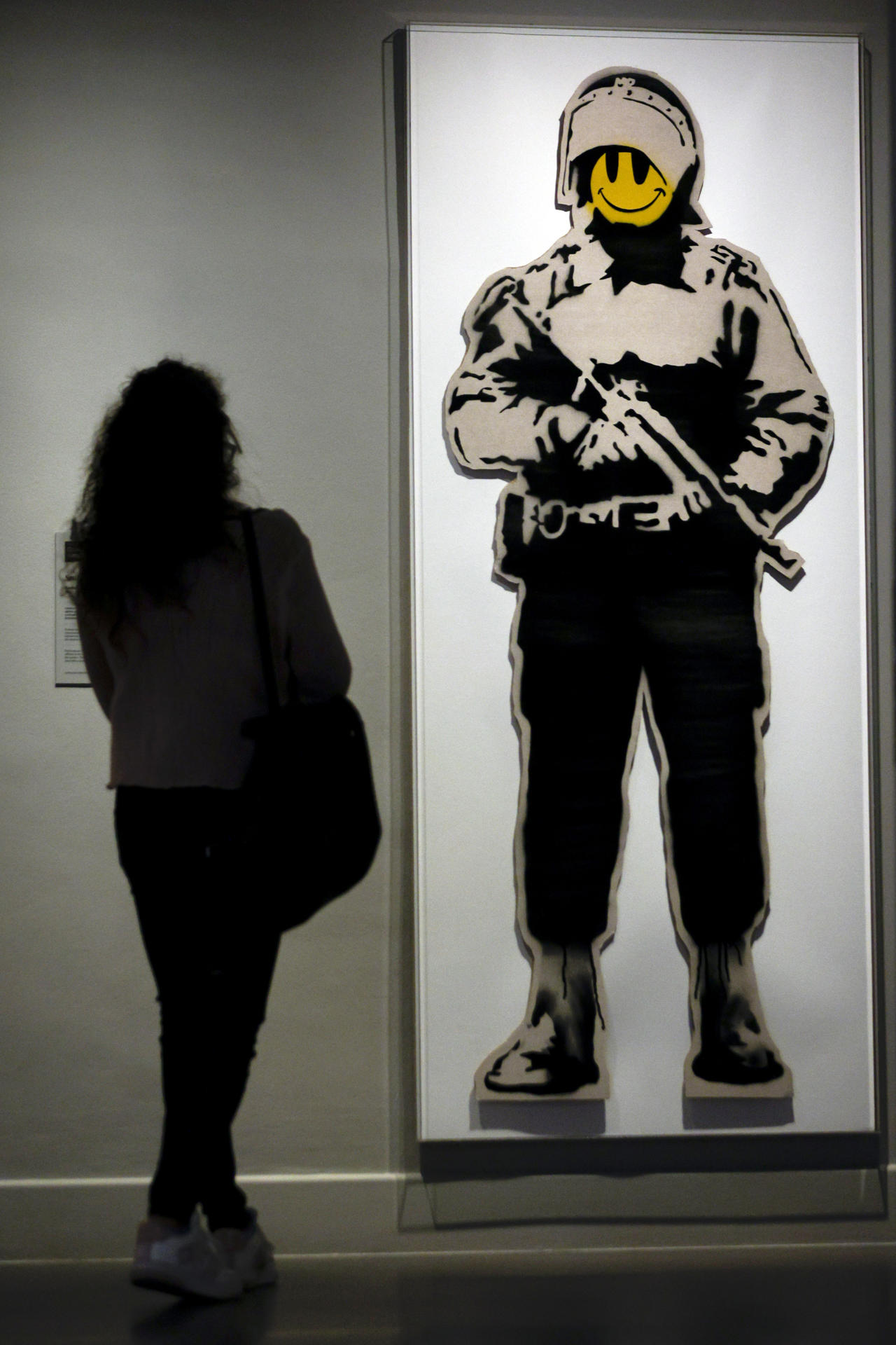 Una persona observa la obra "Smiling Copper", de Banksy, una de las obras que se muestra en el Museo del Arte Prohibido. EFE/Quique García