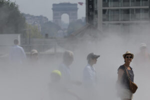 Varias personas caminan entre nebulizadores de agua para refrescarse en el centro de París, Francia, en una fotografía de archivo. EFE/ Lavandeira Jr