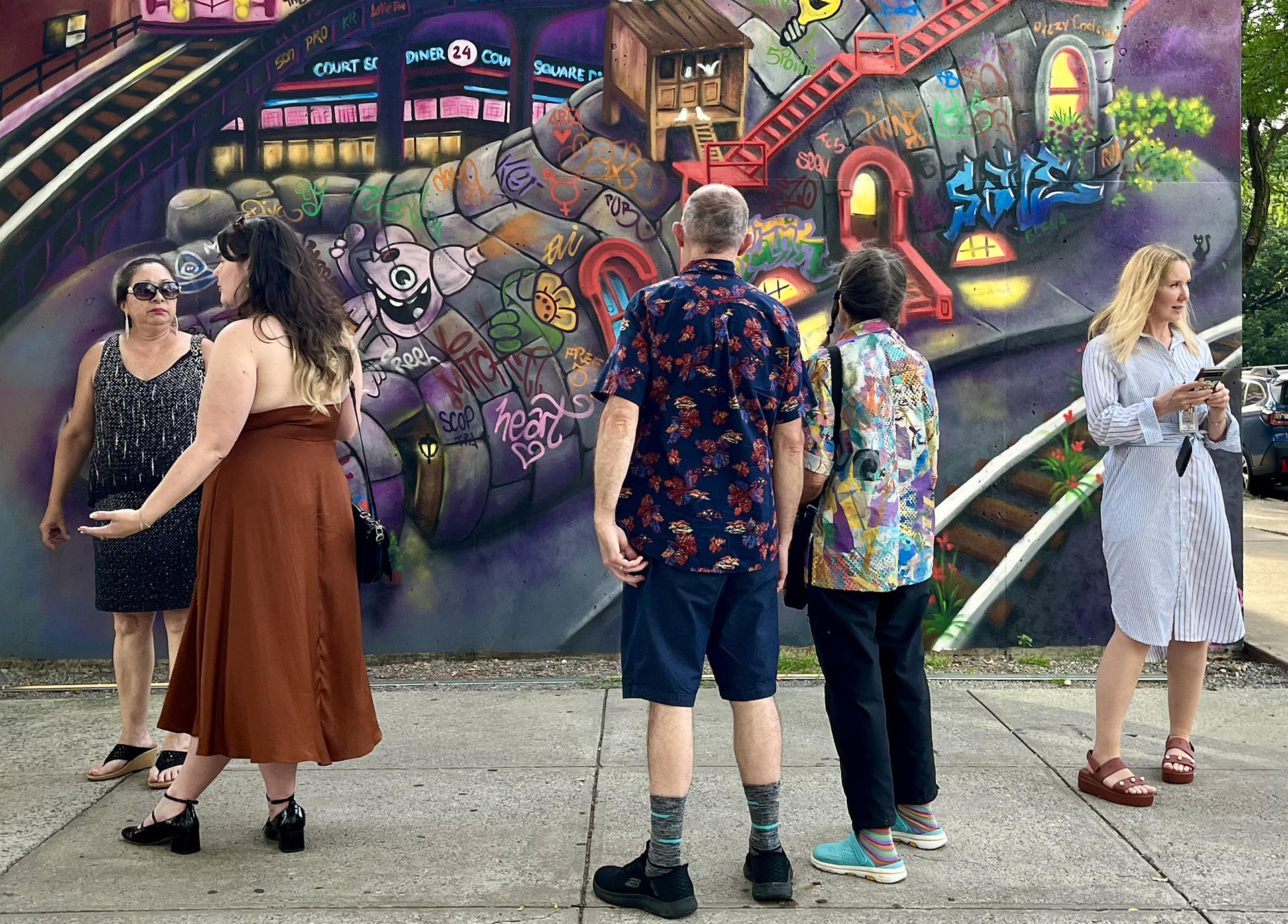 Personas observan un mural de la grafitera estadounidense de origen ecuatoriano Lady Pink este lunes, en Nueva York (Estados Unidos). EFE/ Andrea Gallego