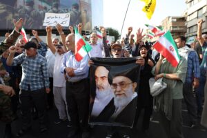 Un manifestante sostiene una pancarta que representa a los líderes supremos iraníes Ali Jamenei (D) y al difunto Ruhollah Jomeini (I) durante una manifestación anti-EE.UU. y anti-Israel en Teherán, el 22 de junio de 2025. EFE/EPA/ABEDIN TAHERKENAREH